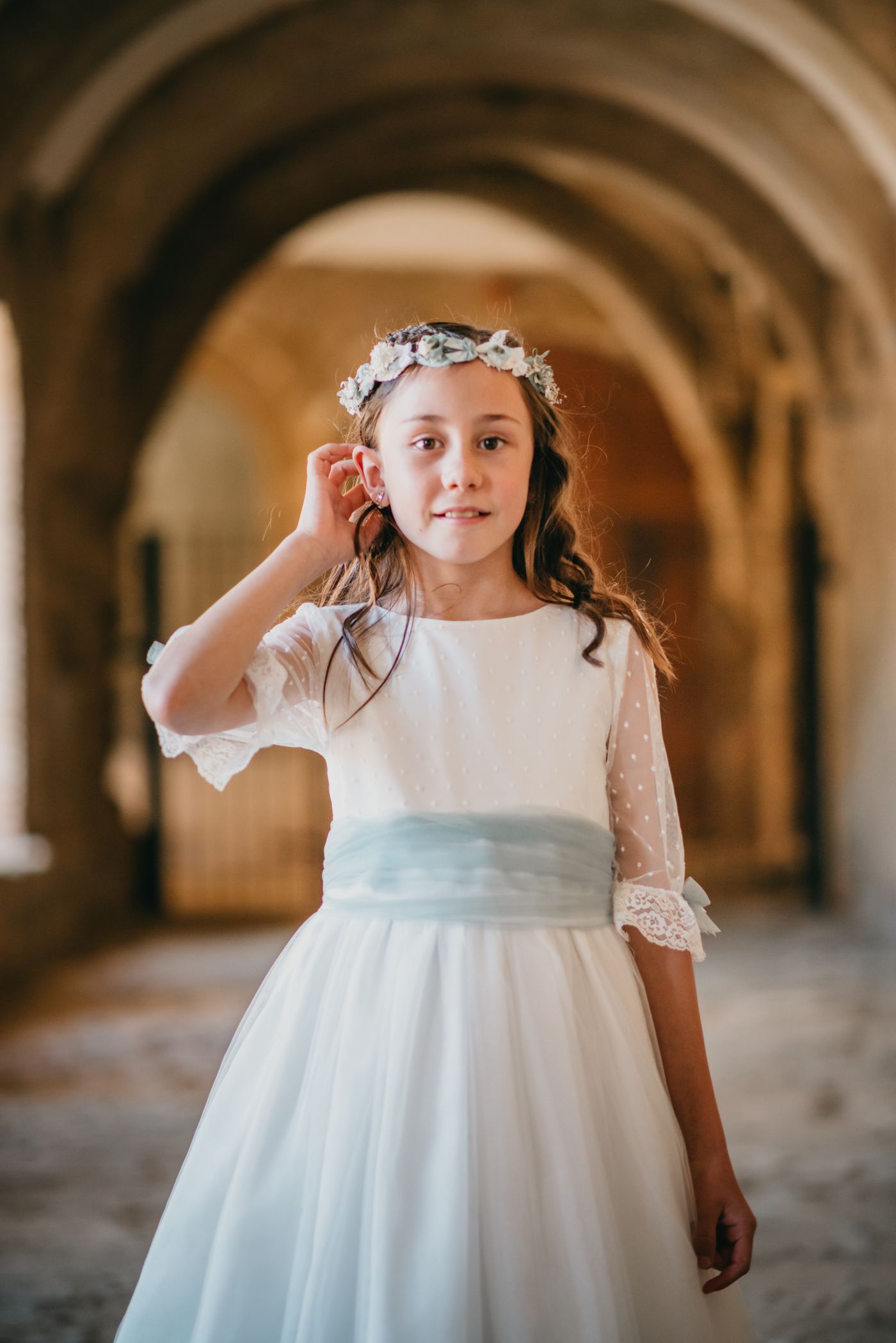 Niña de comunión en un claustro de piedra