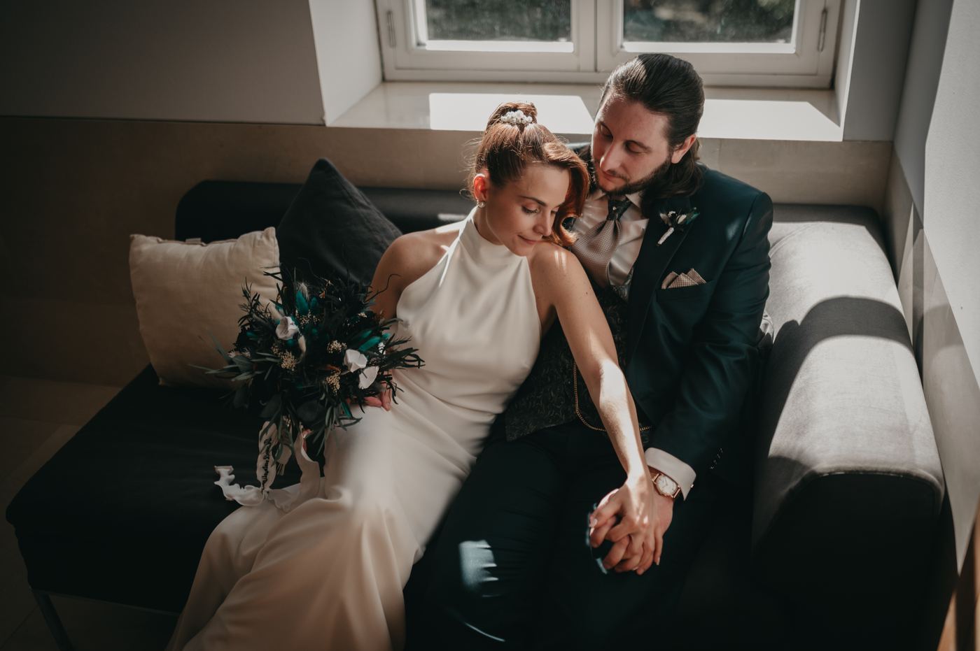Novios sentados en un sofá junto a la ventana